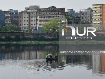 Children ride in a boat as it moves through the pitch-black water of the old Buriganga River channel in Dhaka, Bangladesh, on September 17,...