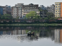 Children ride in a boat as it moves through the pitch-black water of the old Buriganga River channel in Dhaka, Bangladesh, on September 17,...