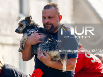 A dog is being evacuated by a policeman after Nysa Klodzka river flooded town of Lewin Brzeski in southwestern Poland, on September 17th, 20...