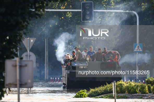 Residents are being evacuated on a military amphibious vehicle by emergency workers after Nysa Klodzka river flooded town of Lewin Brzeski i...