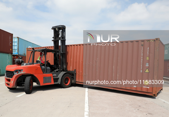 A worker drives a forklift truck to load and unload containers at Nanchang International Dry Port in Nanchang, China, on September 18, 2024....