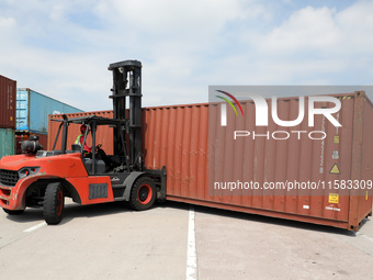 A worker drives a forklift truck to load and unload containers at Nanchang International Dry Port in Nanchang, China, on September 18, 2024....