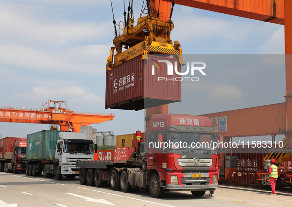 Workers lift containers at Nanchang International Dry Port in Nanchang, China, on September 18, 2024. 