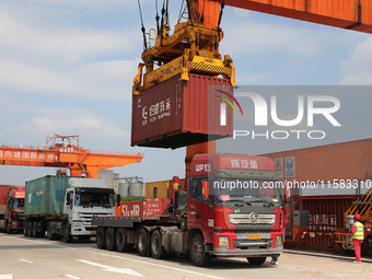 Workers lift containers at Nanchang International Dry Port in Nanchang, China, on September 18, 2024. (