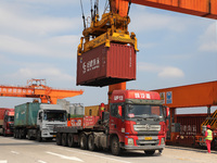 Workers lift containers at Nanchang International Dry Port in Nanchang, China, on September 18, 2024. (