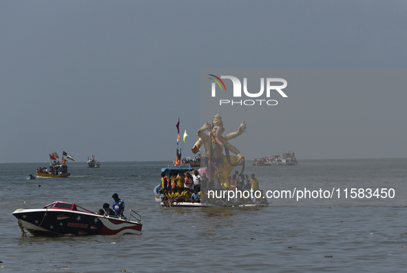 Devotees carry an idol of the elephant-headed god Lord Ganesha during an immersion procession to the Arabian Sea in Mumbai, India, on Septem...