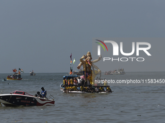 Devotees carry an idol of the elephant-headed god Lord Ganesha during an immersion procession to the Arabian Sea in Mumbai, India, on Septem...