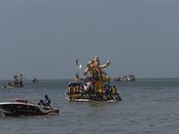 Devotees carry an idol of the elephant-headed god Lord Ganesha during an immersion procession to the Arabian Sea in Mumbai, India, on Septem...