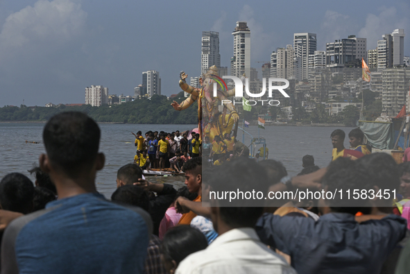 Devotees carry an idol of the elephant-headed god Lord Ganesha during an immersion procession to the Arabian Sea in Mumbai, India, on Septem...