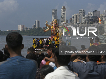 Devotees carry an idol of the elephant-headed god Lord Ganesha during an immersion procession to the Arabian Sea in Mumbai, India, on Septem...