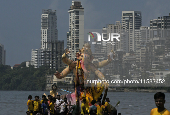 Devotees carry an idol of the elephant-headed god Lord Ganesha during an immersion procession to the Arabian Sea in Mumbai, India, on Septem...