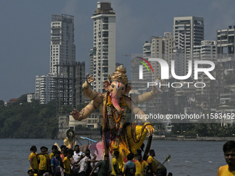 Devotees carry an idol of the elephant-headed god Lord Ganesha during an immersion procession to the Arabian Sea in Mumbai, India, on Septem...