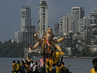 Devotees carry an idol of the elephant-headed god Lord Ganesha during an immersion procession to the Arabian Sea in Mumbai, India, on Septem...