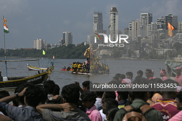 Devotees carry an idol of the elephant-headed god Lord Ganesha during an immersion procession to the Arabian Sea in Mumbai, India, on Septem...