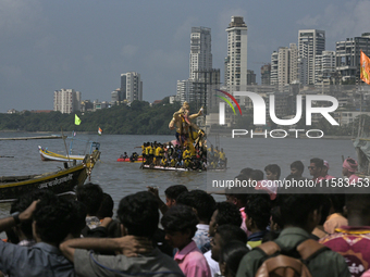 Devotees carry an idol of the elephant-headed god Lord Ganesha during an immersion procession to the Arabian Sea in Mumbai, India, on Septem...