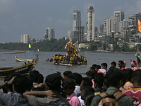 Devotees carry an idol of the elephant-headed god Lord Ganesha during an immersion procession to the Arabian Sea in Mumbai, India, on Septem...