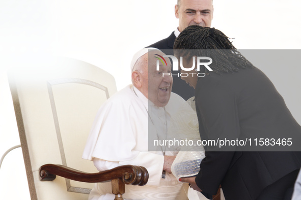 Pope Francis smiles at a pilgrim at the end of his Wednesday general audience in Saint Peter's Square 