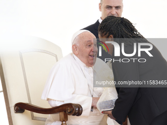 Pope Francis smiles at a pilgrim at the end of his Wednesday general audience in Saint Peter's Square (