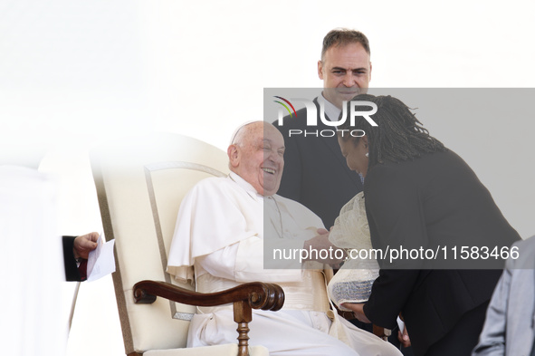 Pope Francis smiles at a pilgrim at the end of his Wednesday general audience in Saint Peter's Square 