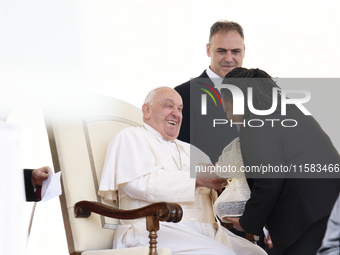 Pope Francis smiles at a pilgrim at the end of his Wednesday general audience in Saint Peter's Square (