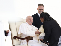 Pope Francis smiles at a pilgrim at the end of his Wednesday general audience in Saint Peter's Square (