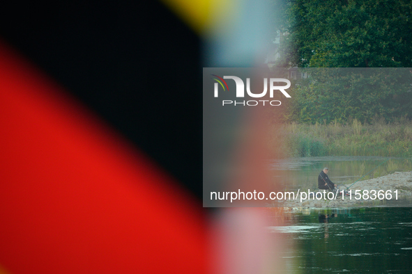 A fisherman is seen on the Polish side of the Oder river in this photo taken in Frankfurt (Oder) on 17 September, 2024. After warnings of in...