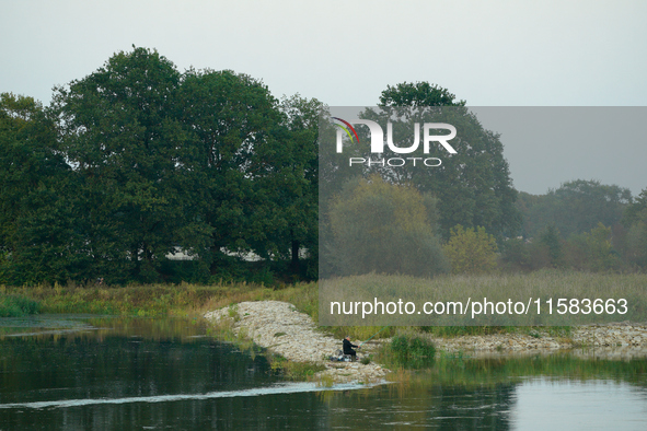 A fisherman is seen on the Polish side of the Oder river in this photo taken in Frankfurt (Oder) on 17 September, 2024. After warnings of in...