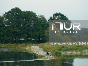 A fisherman is seen on the Polish side of the Oder river in this photo taken in Frankfurt (Oder) on 17 September, 2024. After warnings of in...