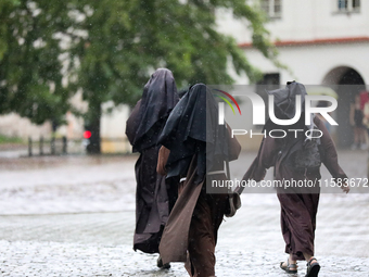 Nuns walk in the rain on the street in Krakow, Poland, on August 21, 2024. (