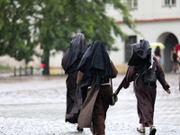 Nuns walk in the rain on the street in Krakow, Poland, on August 21, 2024. (