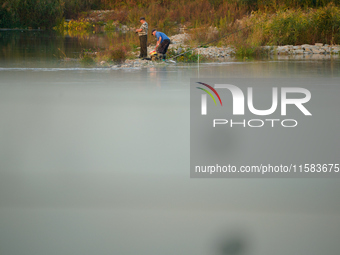 Fishermen are seen on the Polish side of the Oder river in this photo taken in Frankfurt (Oder) on 17 Septembe, 2024. After warnings of incr...