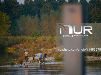 Fishermen are seen on the Polish side of the Oder river in this photo taken in Frankfurt (Oder) on 17 Septembe, 2024. After warnings of incr...