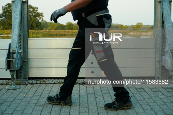 A member of the local fire brigade walks past a newly installed flood barrier in Frankfurt (Oder) on 17 Septembe, 2024. After warnings of in...