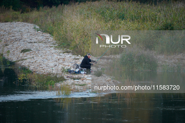 A fisherman is seen on the Polish side of the Oder river in this photo taken in Frankfurt (Oder) on 17 September, 2024. After warnings of in...