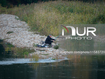 A fisherman is seen on the Polish side of the Oder river in this photo taken in Frankfurt (Oder) on 17 September, 2024. After warnings of in...