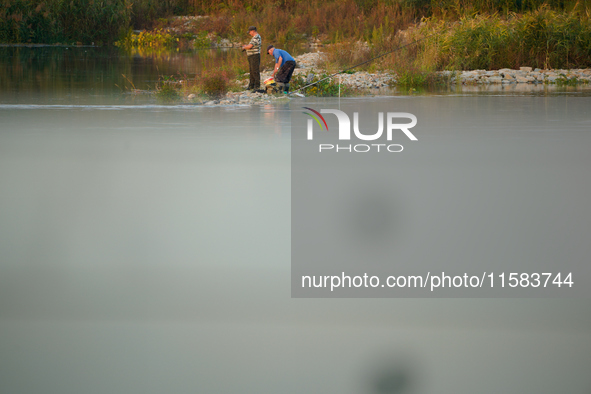 Fishermen are seen on the Polish side of the Oder river in this photo taken in Frankfurt (Oder) on 17 Septembe, 2024. After warnings of incr...