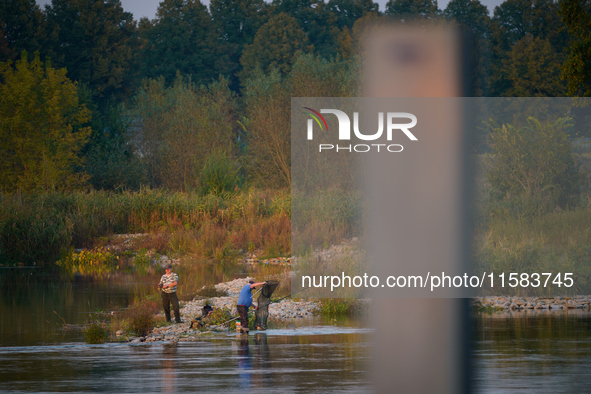 Fishermen are seen on the Polish side of the Oder river in this photo taken in Frankfurt (Oder) on 17 Septembe, 2024. After warnings of incr...