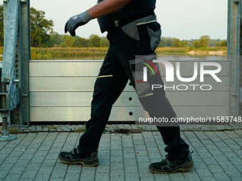 A member of the local fire brigade walks past a newly installed flood barrier in Frankfurt (Oder) on 17 Septembe, 2024. After warnings of in...