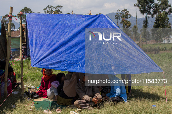 People take shelter in a soccer field after a 5.0 magnitude earthquake strikes in Kertasari, West Java, on September 18, 2024. At least 700...