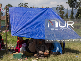 People take shelter in a soccer field after a 5.0 magnitude earthquake strikes in Kertasari, West Java, on September 18, 2024. At least 700...