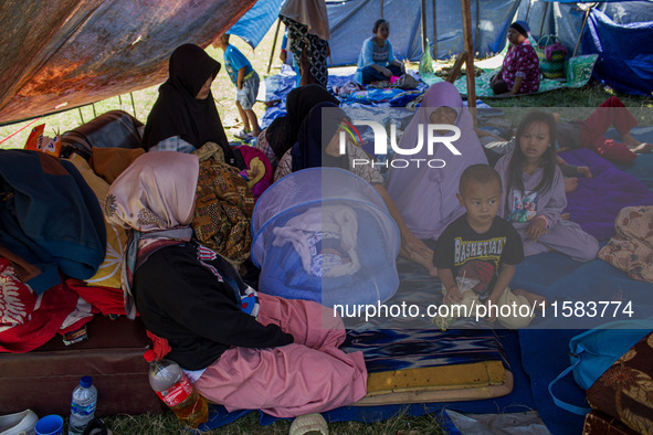 People take shelter in a soccer field after a 5.0 magnitude earthquake strikes in Kertasari, West Java, on September 18, 2024. At least 700...