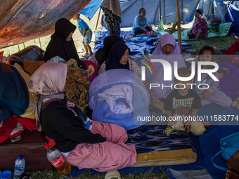 People take shelter in a soccer field after a 5.0 magnitude earthquake strikes in Kertasari, West Java, on September 18, 2024. At least 700...