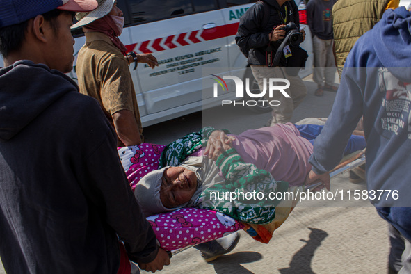 Officers evacuate victims after a 5.0 magnitude earthquake strikes Kertasari, West Java, on September 18, 2024. At least 700 houses are dama...