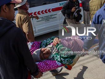 Officers evacuate victims after a 5.0 magnitude earthquake strikes Kertasari, West Java, on September 18, 2024. At least 700 houses are dama...