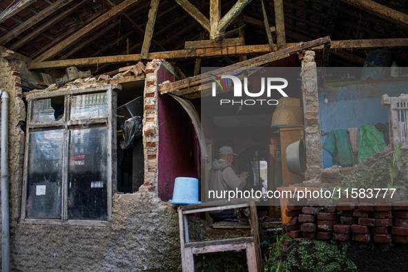 A man stands at his collapsed house after a 5.0 magnitude earthquake strikes in Kertasari, West Java, on September 18, 2024. At least 700 ho...