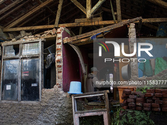 A man stands at his collapsed house after a 5.0 magnitude earthquake strikes in Kertasari, West Java, on September 18, 2024. At least 700 ho...