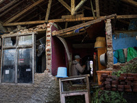 A man stands at his collapsed house after a 5.0 magnitude earthquake strikes in Kertasari, West Java, on September 18, 2024. At least 700 ho...