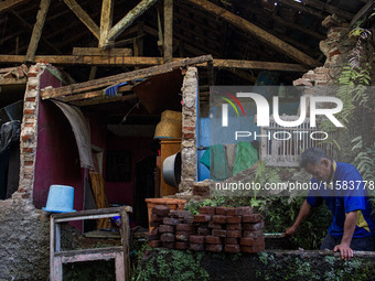 A man stands at his collapsed house after a 5.0 magnitude earthquake strikes in Kertasari, West Java, on September 18, 2024. At least 700 ho...