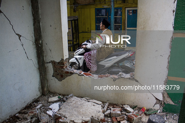 A motorcycle passes a collapsed wall after a 5.0 magnitude earthquake strikes in Kertasari, West Java, on September 18, 2024. At least 700 h...