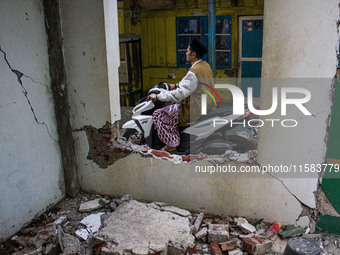 A motorcycle passes a collapsed wall after a 5.0 magnitude earthquake strikes in Kertasari, West Java, on September 18, 2024. At least 700 h...